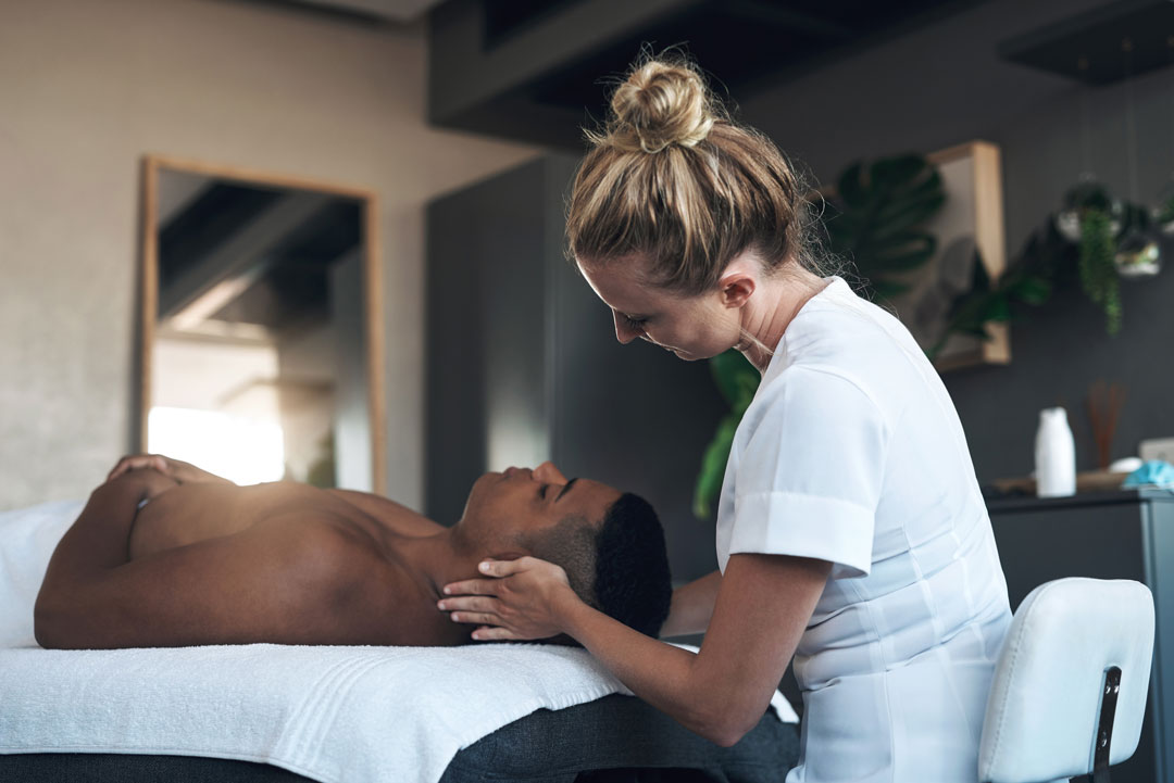 A beautiful spa attendant giving massage to a black man